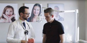 A dentist talking with their patient at their regular checkup.