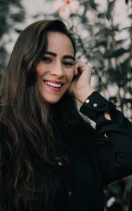 A young woman smiling confidently after cosmetic dental treatement in Roy.