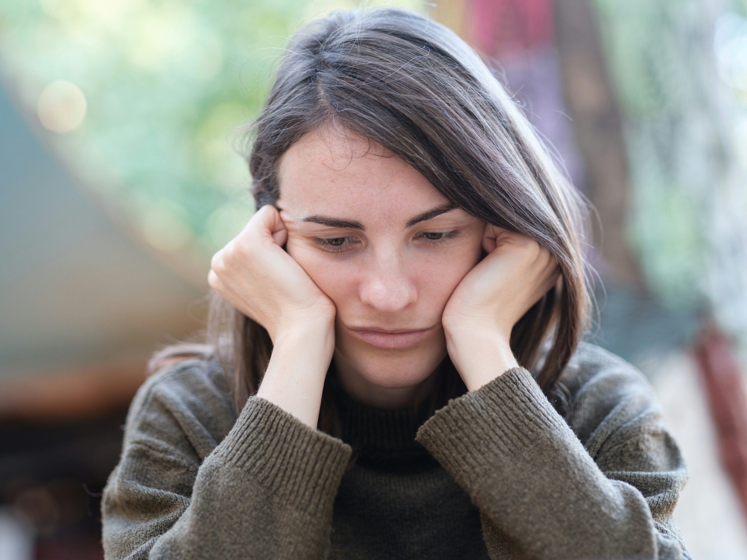 Woman rests her face on her hands in a show of discomfort